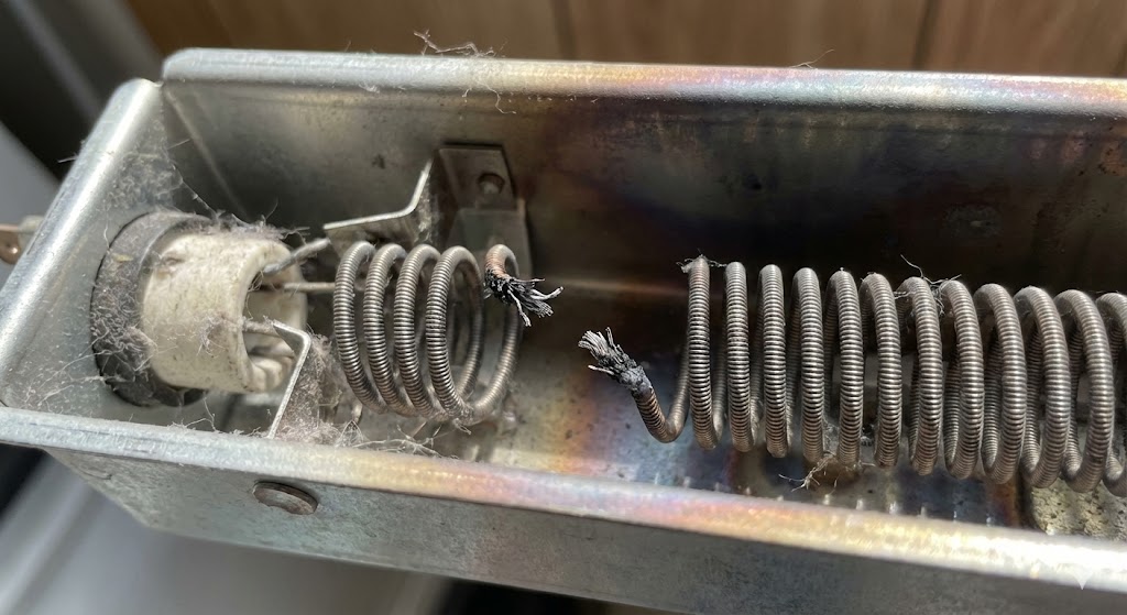 A close-up view of a dryer heating element coil with a visible break in the wire