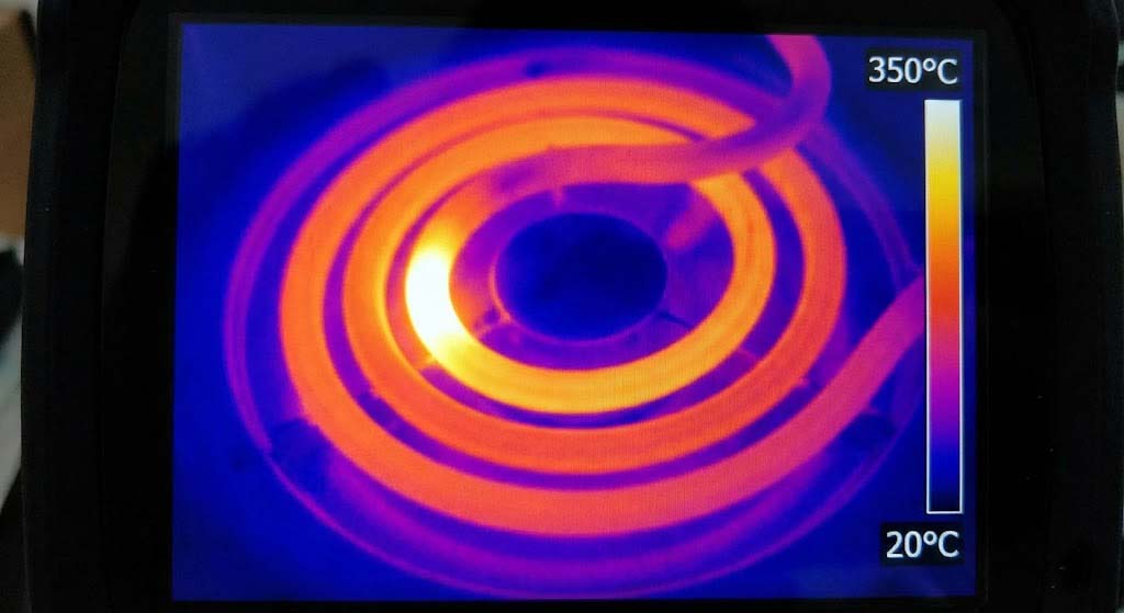 A thermal image showing a bright hot spot on a heating element coil