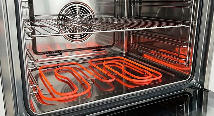 Close-up of a healthy oven heating element glowing bright orange during operation, indicating even heat distribution and proper function.